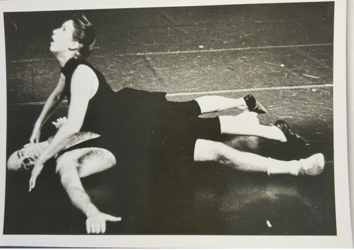Brigitta Herrmann in black leaning over Michael A. Carson as he lies on his back on a dark stage floor in Once Bitten Twice Shy