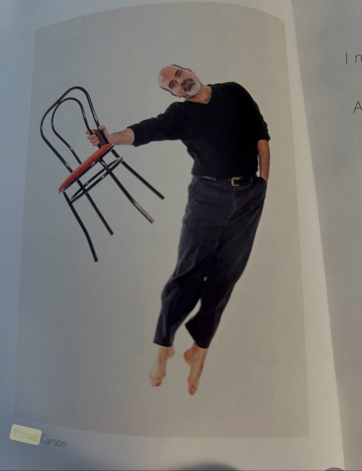Michael A. Carson suspended mid-leap while holding a bentwood chair