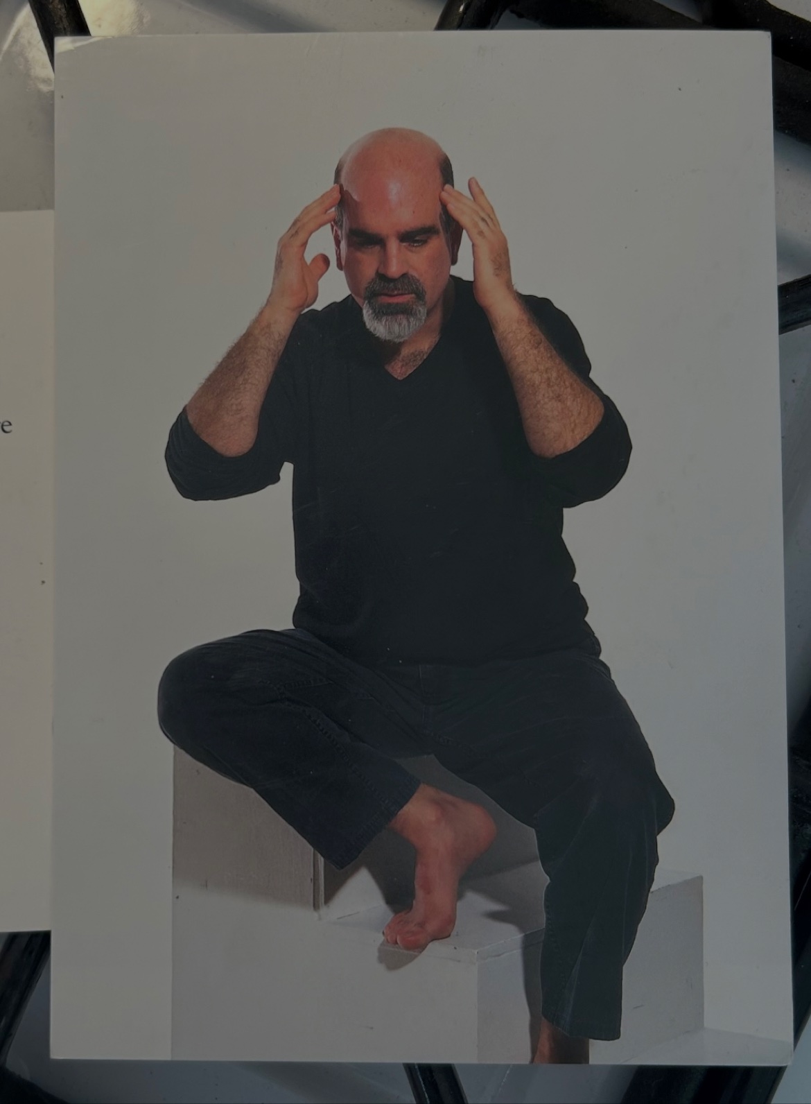 Michael A. Carson seated barefoot in black with both hands raised beside his head in a 2002 publicity portrait for Integrity Brings With It An Empty Plate